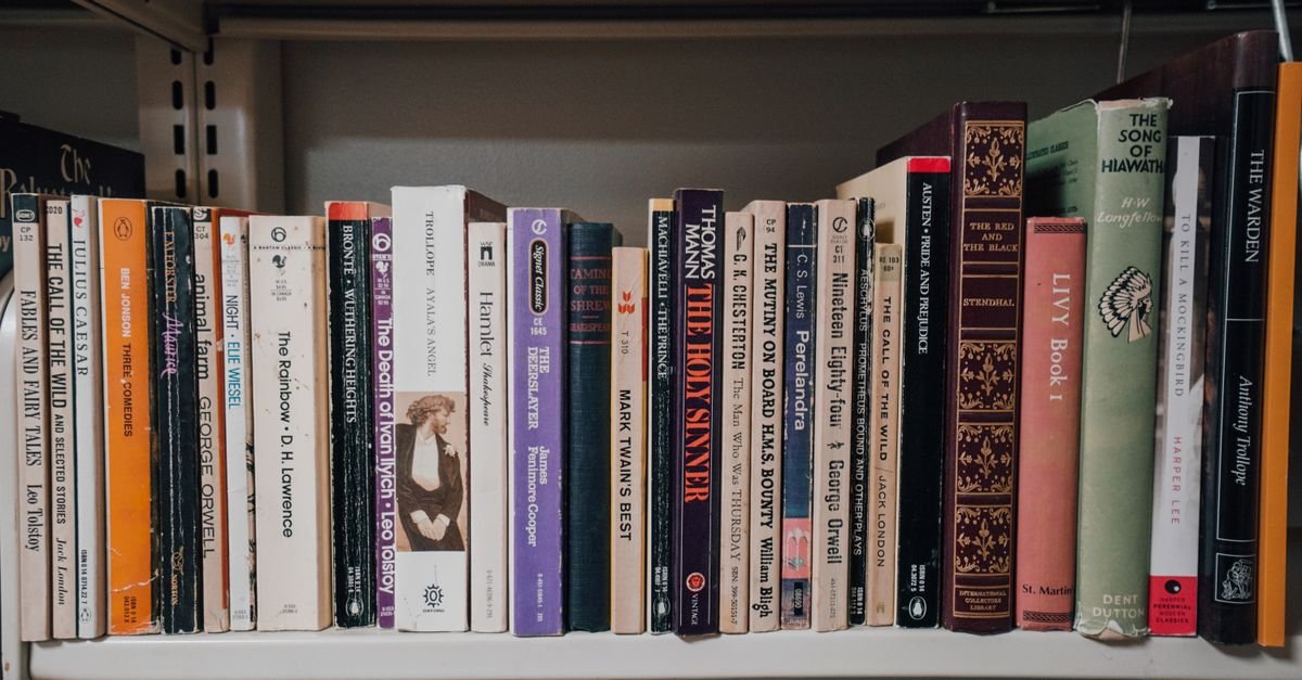 A shelf of mixed reference books of different sizes and colours