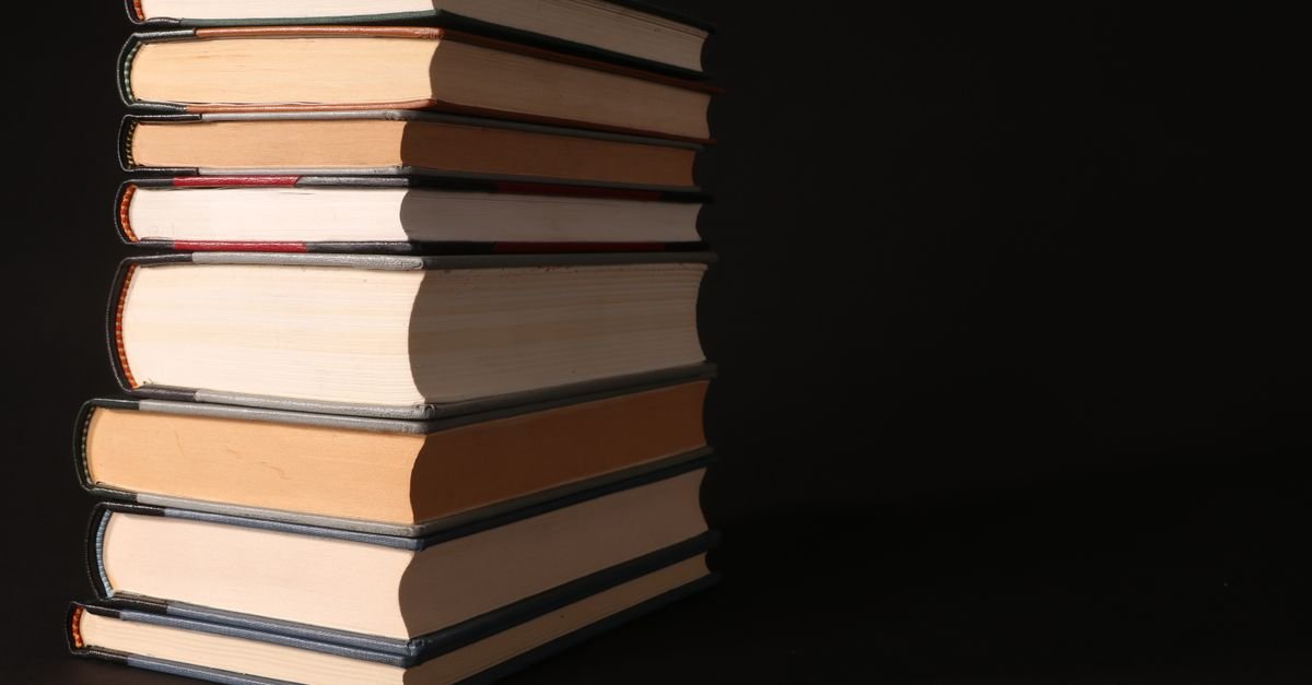 Stack of thick reference books on a dark background