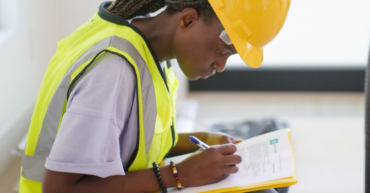 Contractor in a hi vis vest writing on a clipboard