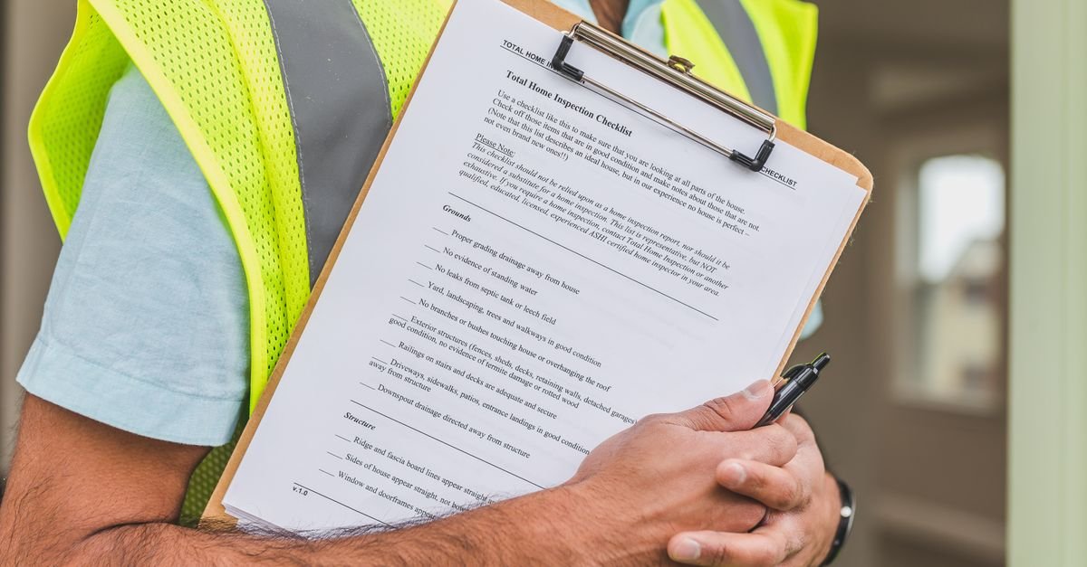 Close up of hands holding a clipboard checklist, the paperwork a contractor licence application turns on