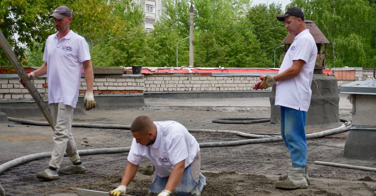 Crew finishing a concrete slab, work a Palm Beach contractors license covers under the concrete category