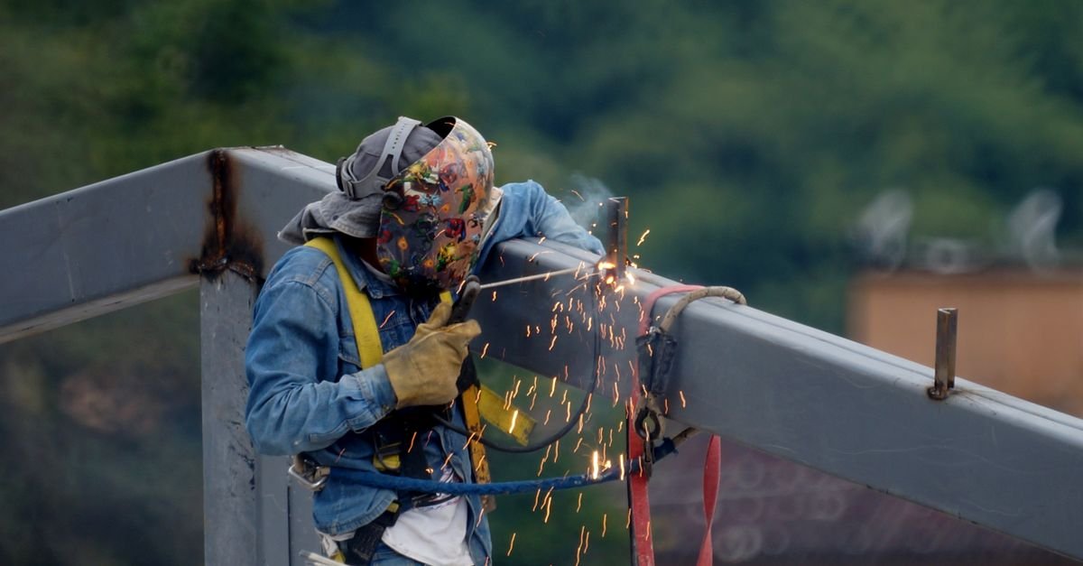 Welder joining a steel beam on site, a structural steel category under the Palm Beach contractors license